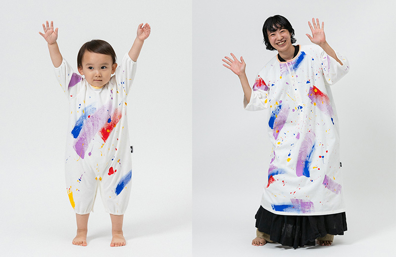 かぞくのおえかきウェアを着用して万歳ポーズをしている親子の写真