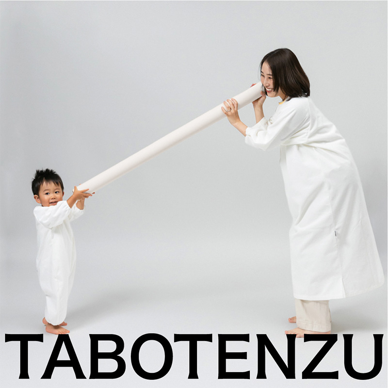 かぞくのおえかきウェアを着用した親子が長い筒を持って遊んでいる写真