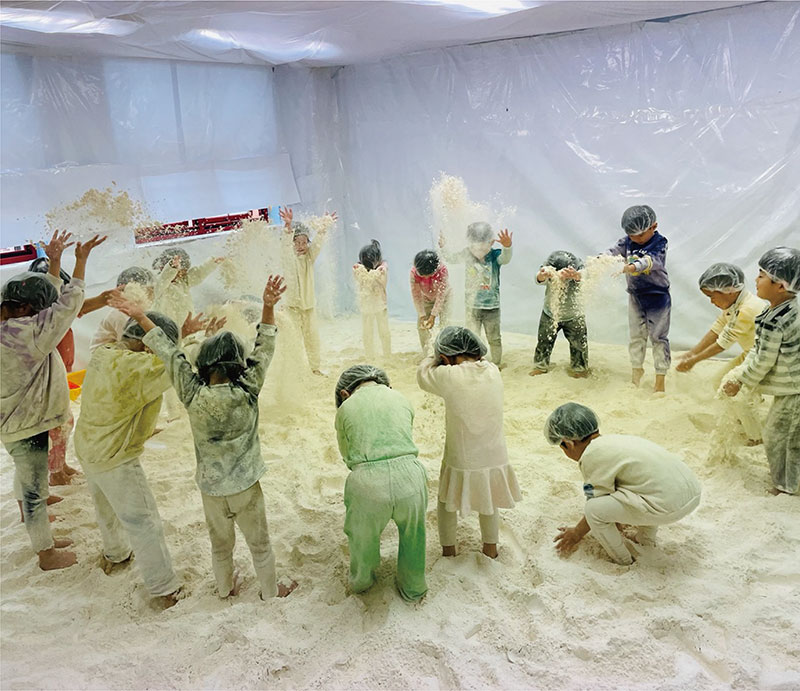 幼稚園のスペシャルデー。小麦遊びを楽しむ様子。