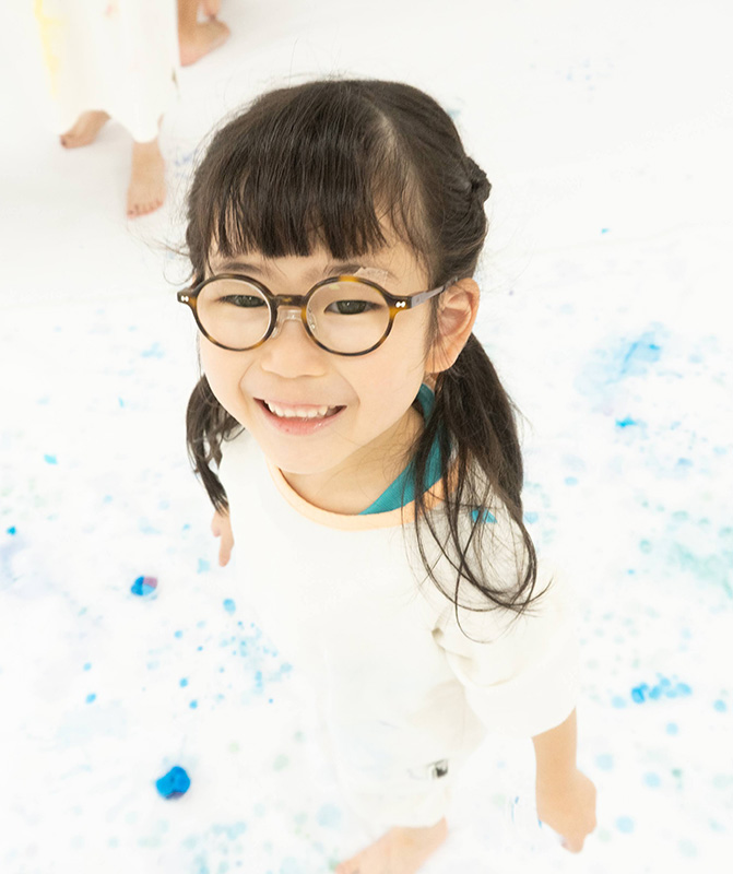 色水氷を模造紙に垂らして絵を描く子供の写真
