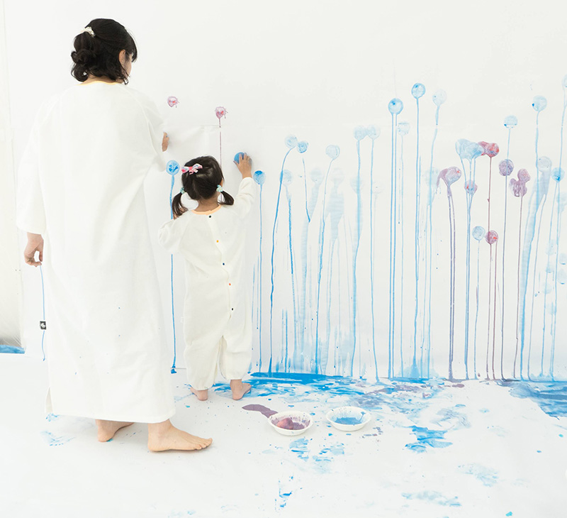 たらし絵で雨の絵を作る親子の写真