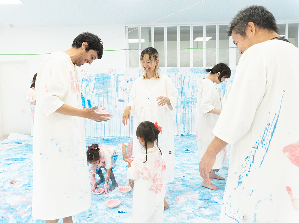 かぞくのおえかきウェアに親子で色を塗り合う様子
