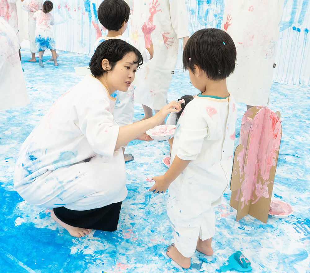 かぞくのおえかきウェアに親子で色を塗り合う様子
