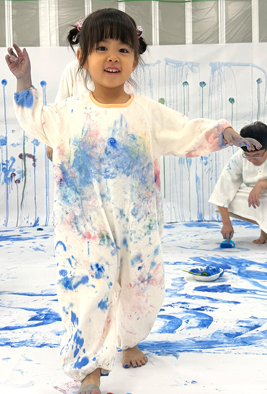 かぞくのおえかきウェアに親子で色を塗り合う様子